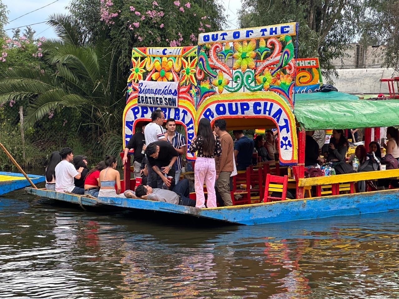 Trajinera navegando con pasajeros por el canal